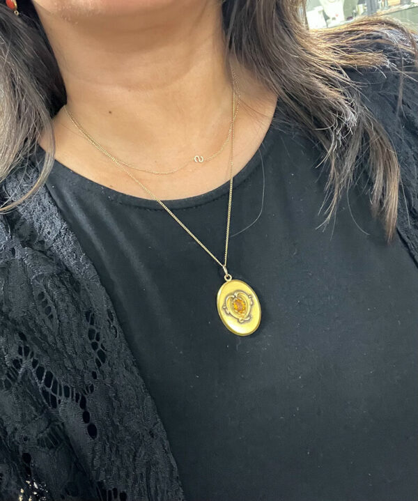 a woman wearing a black top and a yellow necklace