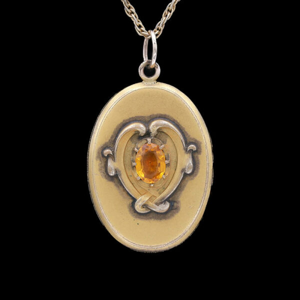 a pendant with an orange stone in the center