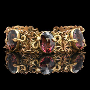 a gold bracelet with three oval shaped stones