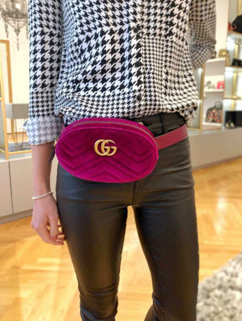 a woman is holding a pink purse in her hand