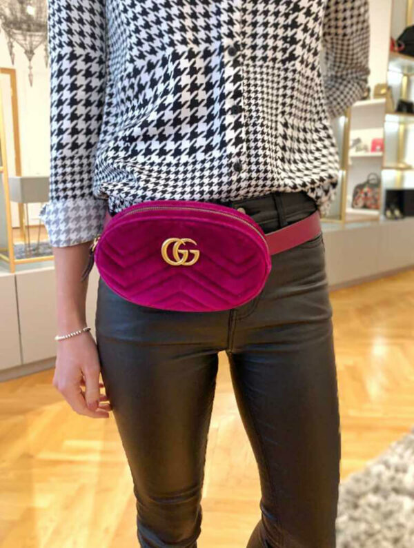 a woman is holding a pink purse in her hand