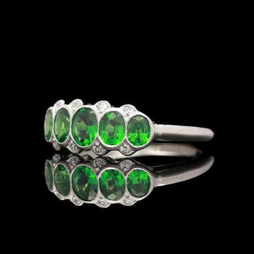 a ring with green stones and diamonds