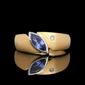 a gold ring with two blue stones on it