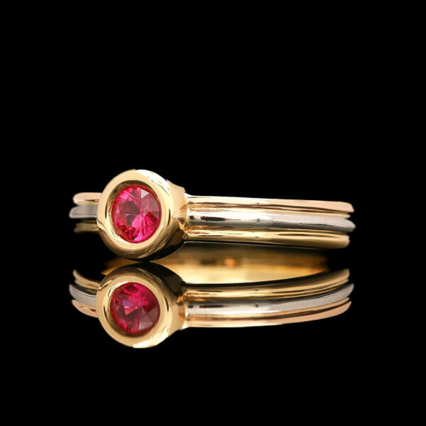 two gold rings with red stones on them