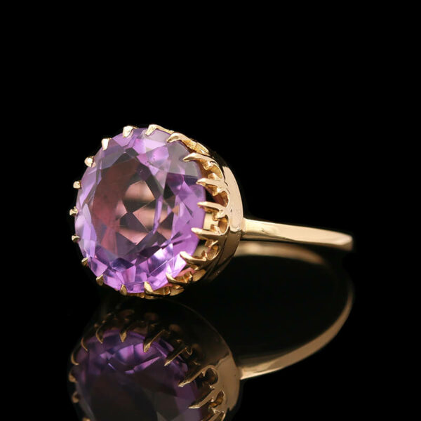 a ring with a large purple stone in it