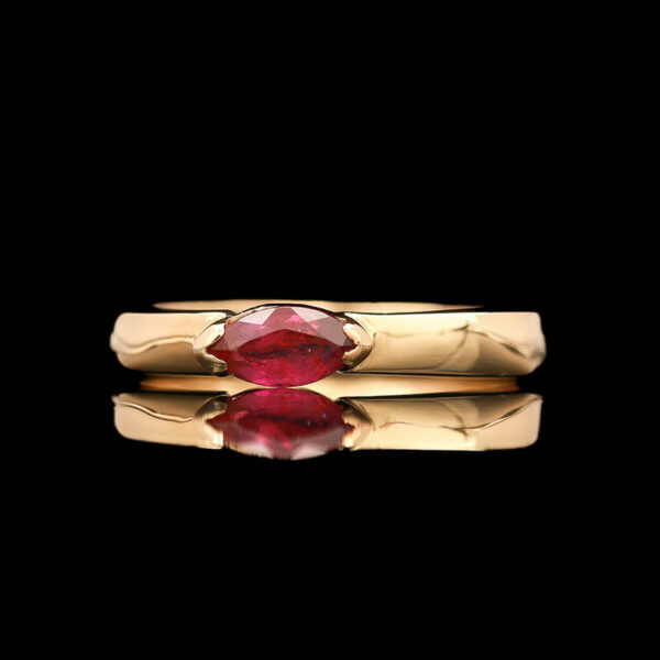 two gold rings with a pink stone on top