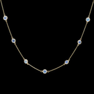 a gold necklace with blue stones on it