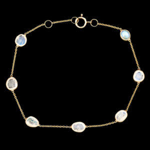 a gold bracelet with white and blue stones