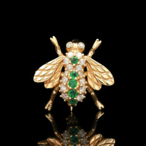 a gold and green insect brooch with diamonds