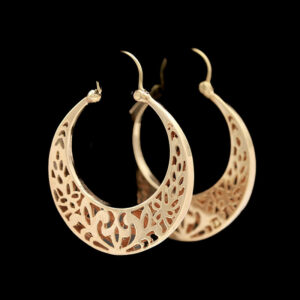a pair of gold hoop earrings with intricate cutouts
