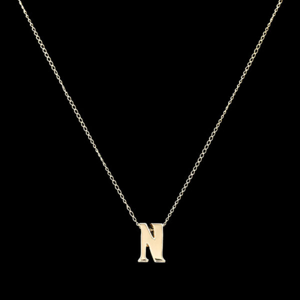 a gold necklace with the letter n on it