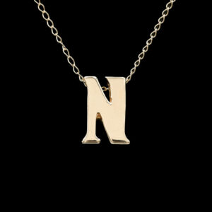 a gold necklace with the letter n on it