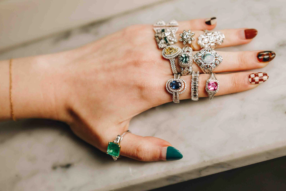a woman's hand with many rings on it