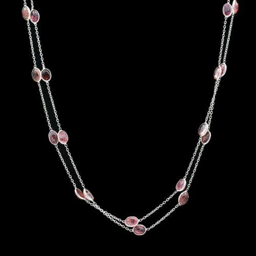 a long necklace with pink stones and silver chains