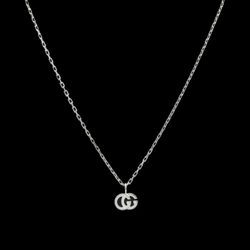 a silver necklace with the letter g on it