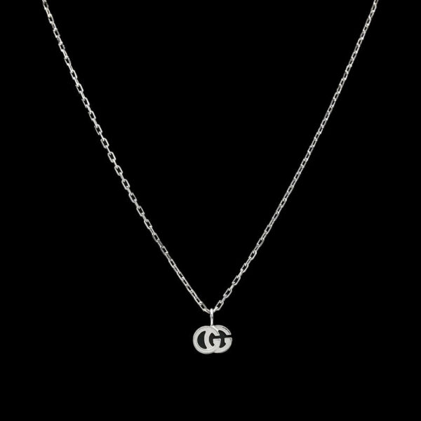 a silver necklace with the letter g on it