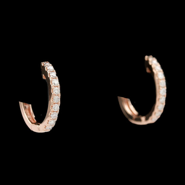 a pair of diamond hoop earrings on a black background