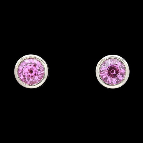 pair of pink crystal earrings on black background