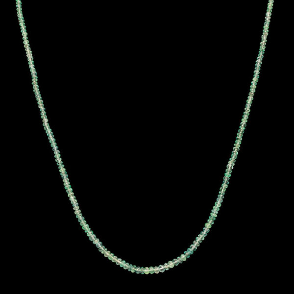 a long necklace with green beads on a black background