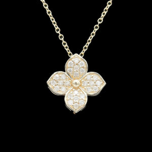 a gold and diamond flower necklace on a black background