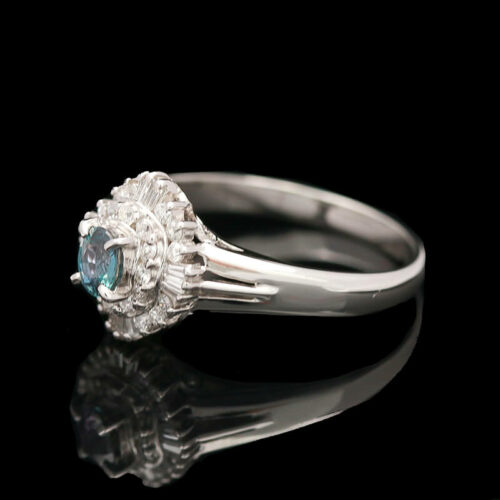 a white gold ring with an oval blue diamond