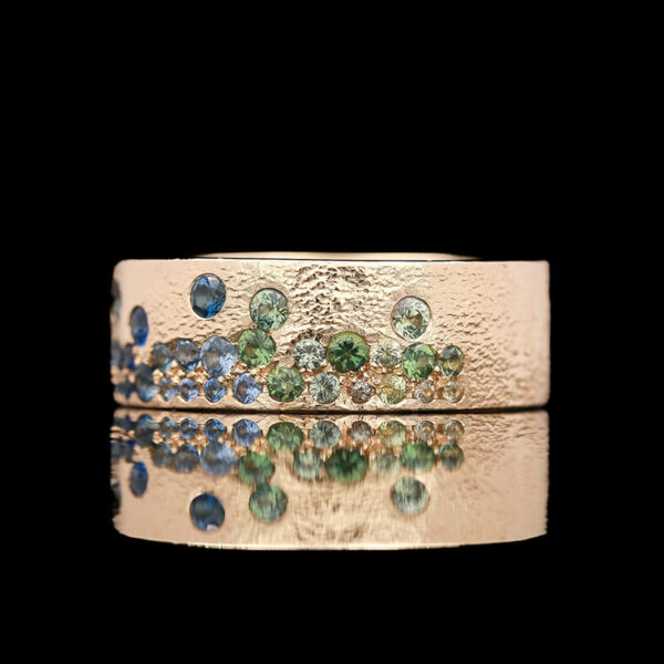 a gold ring with blue and green stones