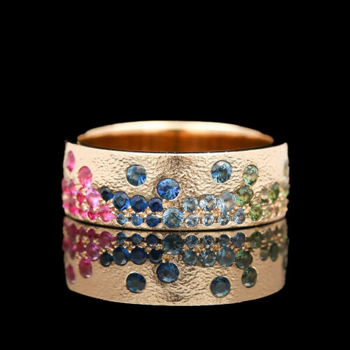a gold ring with different colored stones on it