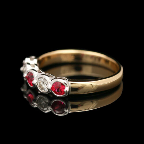 two gold rings with red and white stones