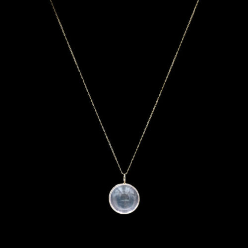 a necklace with a glass disc hanging from it