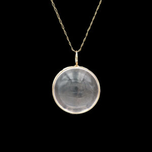 a necklace with a glass disc hanging from it