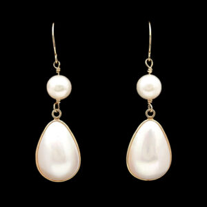 pair of earrings with white pearls on black background