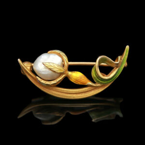 a brooch with leaves and pearls on it