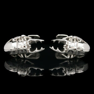 two silver cufflinks on a black background