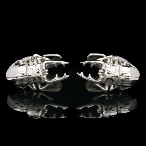 two silver cufflinks on a black background
