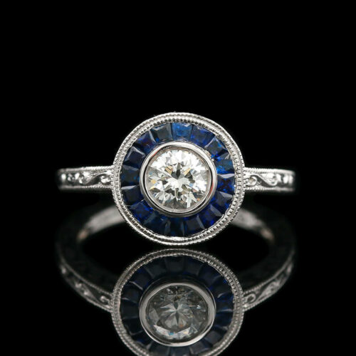 a diamond and blue sapphire ring on a black background