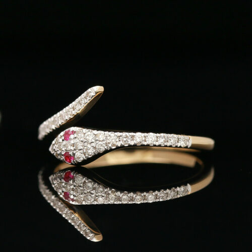 a diamond and ruby ring on a black surface