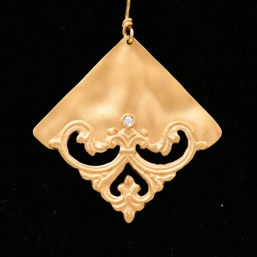 a gold pendant with a diamond in the center