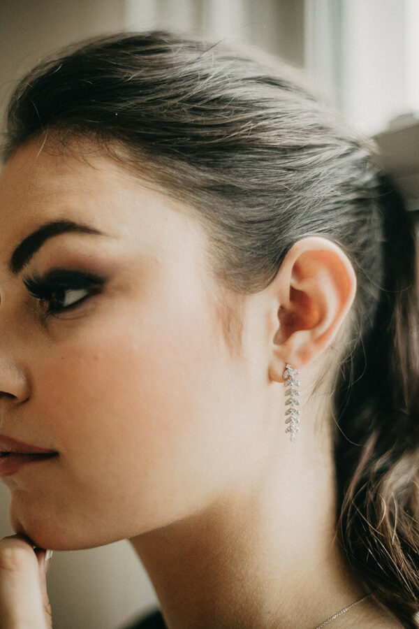 a woman with black eyeliner and earrings on