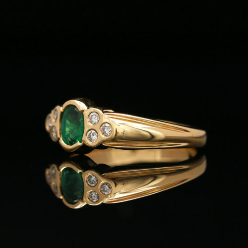 a gold ring with an emerald and diamonds