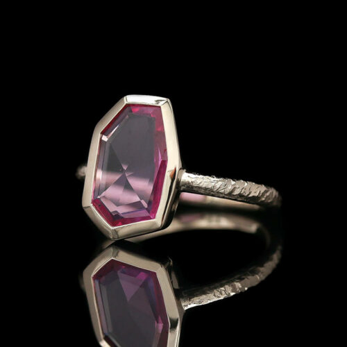a ring with a large pink stone in it