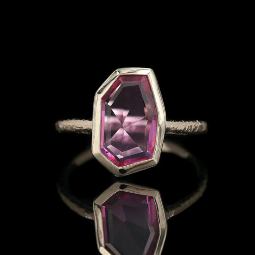 a pink tourmaline stone is set in a silver ring
