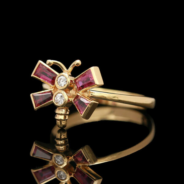a close up of a gold ring with pink stones