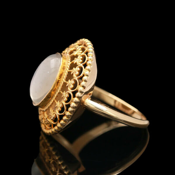 a gold ring with a white stone in the middle