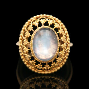 a gold ring with a white stone in the center