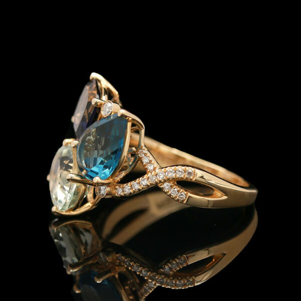 a gold ring with blue and green stones