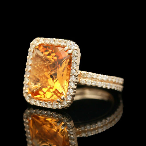 an orange and white diamond ring on a black surface