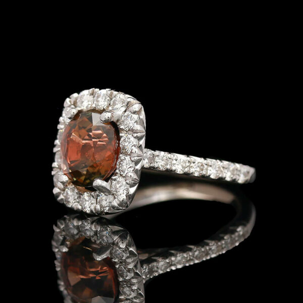 an orange and white diamond ring on a black surface
