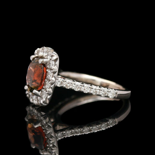 a fancy ring with an orange stone surrounded by diamonds