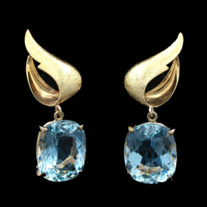 a pair of earrings with blue topaz and gold accents