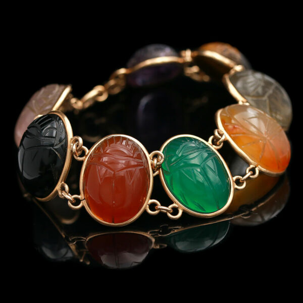 a gold bracelet with multi colored stones on it
